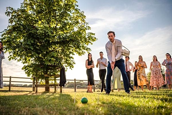 A group of people playing a game of croquet at Dodford Manor Wedding Photographer