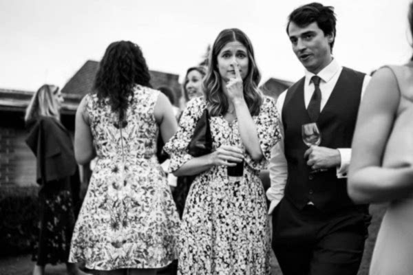 A black and white photo capturing the joyful ambiance of a Dodford Manor wedding party.