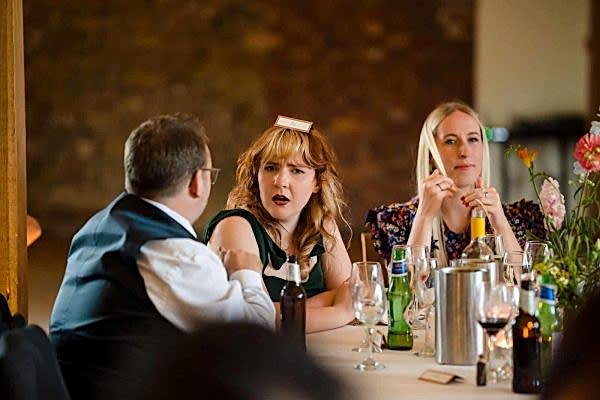 A group of people sitting around a table at a Dodford Manor wedding.