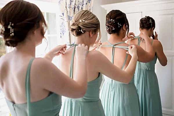 Bridesmaids at Dodford Manor putting on their dresses in front of a mirror.