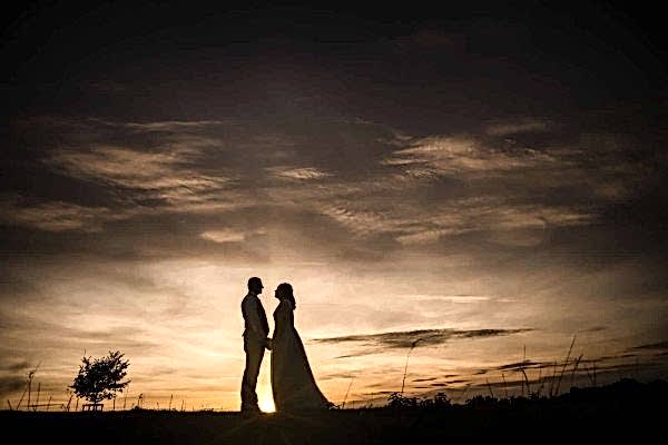 A breathtaking silhouette of a bride and groom at sunset captured by Dodford Manor Wedding Photographer.