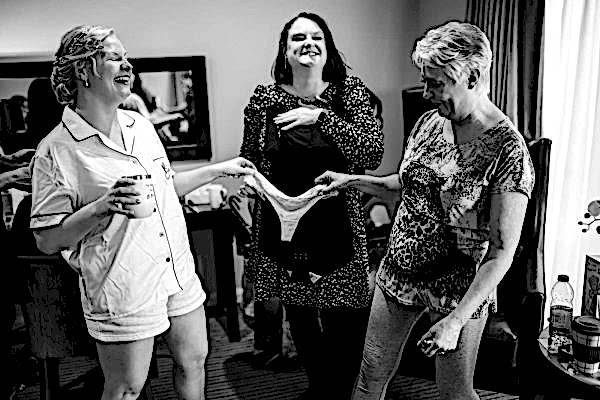 A bride getting ready in a hotel room with her bridesmaids for her Dodford Manor Wedding.