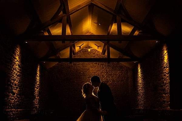 Couple kissing in stone barn