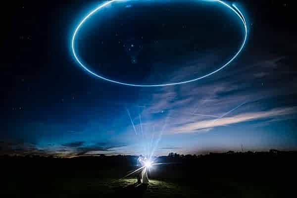 A Dodford Manor wedding photographer capturing a man standing in a field with a circle in the sky.