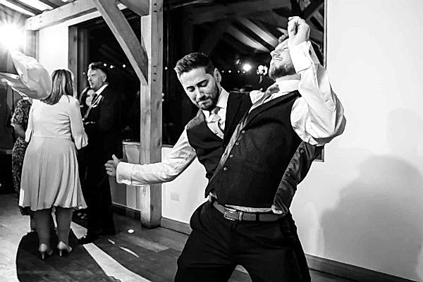Dodford Manor Wedding Photographer capturing two men dancing at a wedding reception.