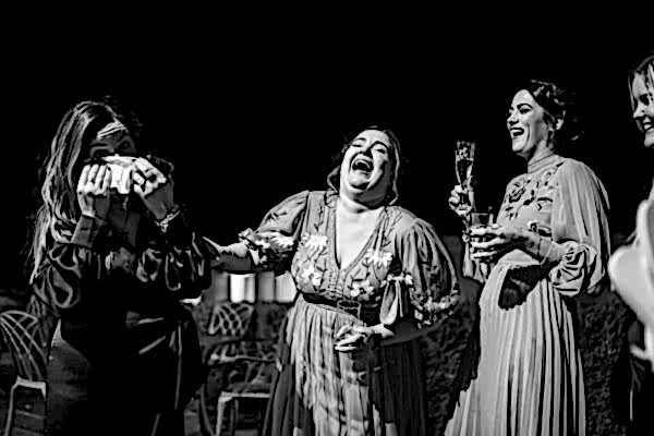 A black and white photo of bridesmaids laughing, captured by a Dodford Manor Wedding Photographer.