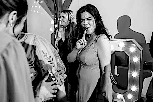 A black and white photo of a woman at a party, taken by a Dodford Manor wedding photographer.