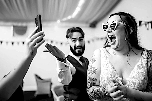 Dodford Manor Wedding Photographer: Capturing the joyful moment of a bride and groom as they take a delightful selfie during their wedding day.