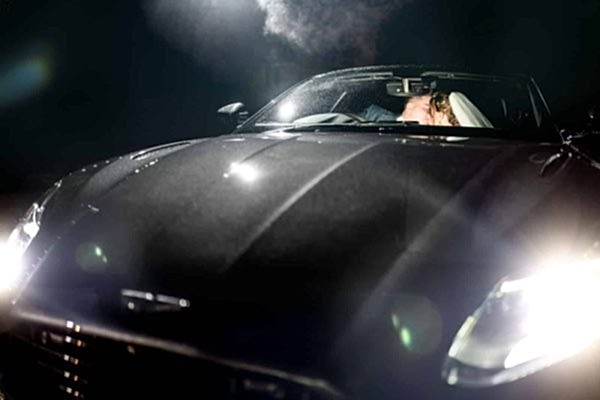 A bride and groom sharing a romantic kiss in a sports car at night, captured beautifully by the Dodford Manor Wedding Photographer.