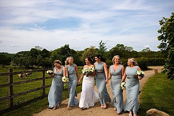 A group of bridesmaids walking down a path captured by a Dodford Manor Wedding Photographer.