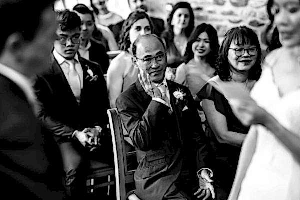 Stunning black and white image capturing a man at a Dodford Manor wedding ceremony.